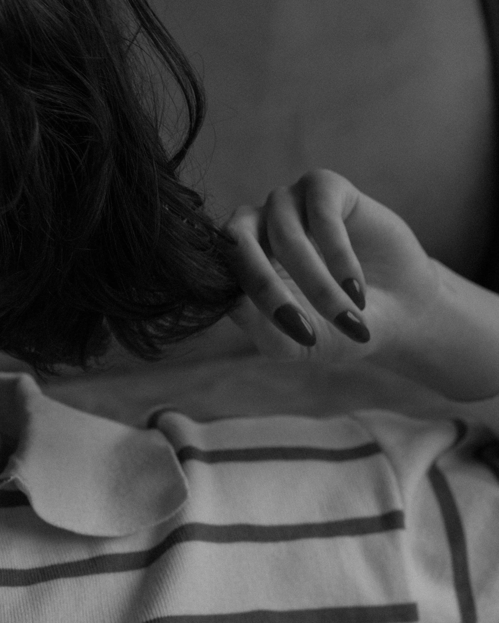 a woman laying down in bed with her hands behind her head