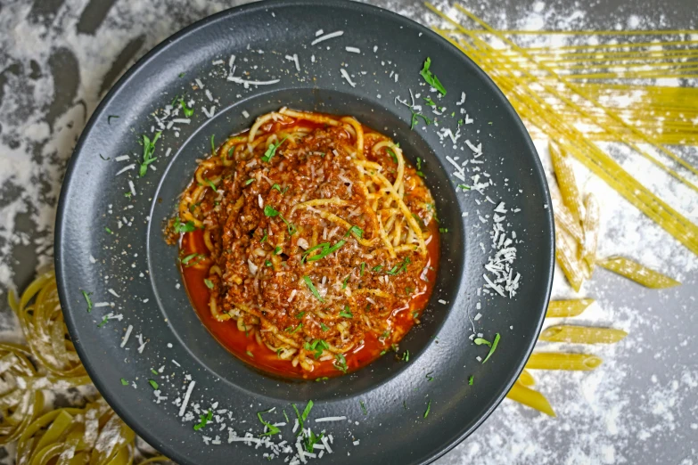 a plate of spaghetti and garlic on a grey tray