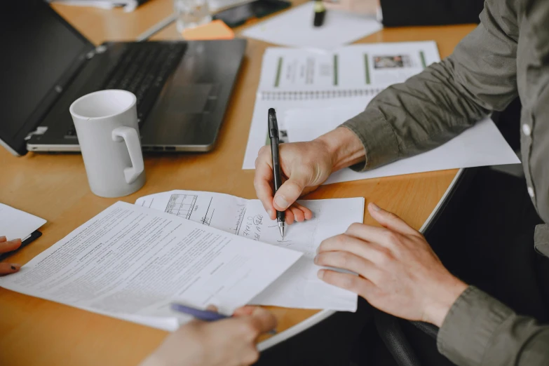 people in a meeting, writing soing on papers