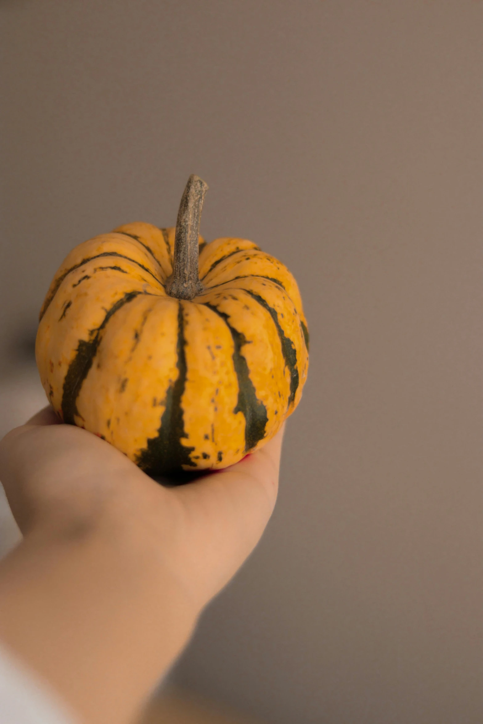 a person is holding a squash that looks like a hand