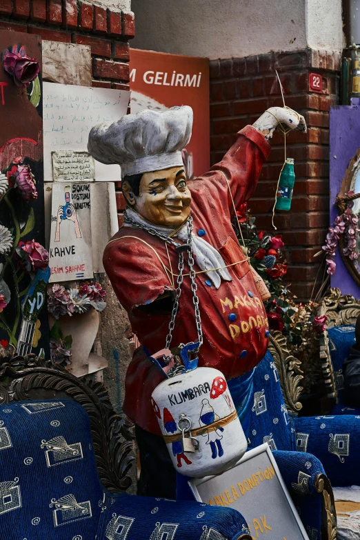 there is a figurine of a cook wearing a hat and holding a large pot