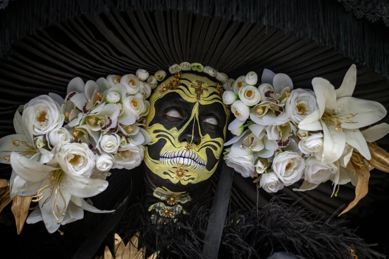 a woman with painted face and black and gold make up