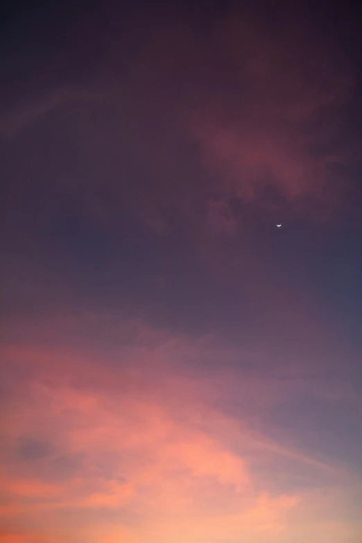 an airplane flying low towards the sun at sunset