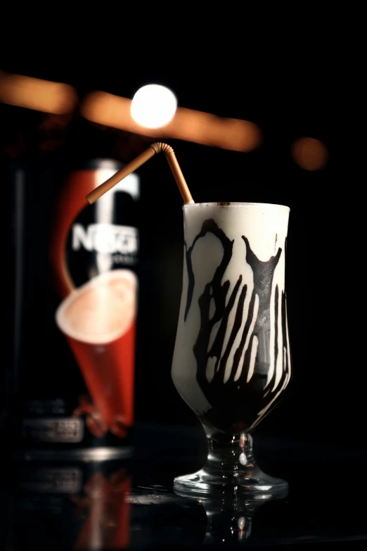 a glass filled with liquid and straw next to a shaker