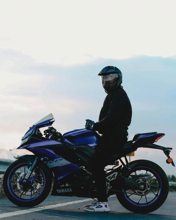 a person standing next to a motorcycle in the road