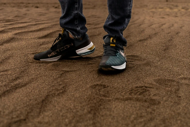 someones feet with their shoe off walking in the sand