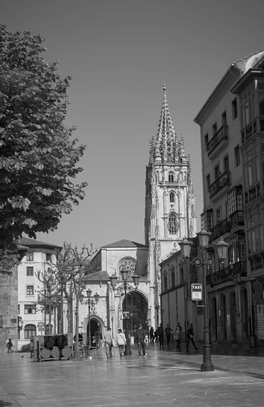 a group of people walking on a road next to a tall tower