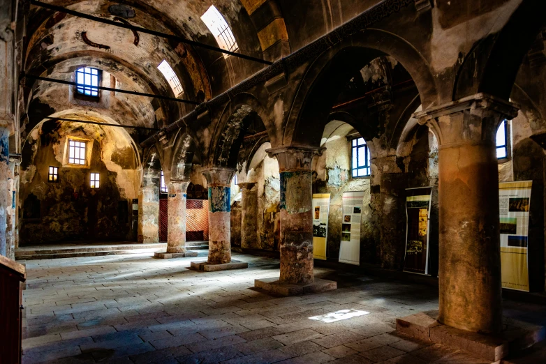 an old stone room has several arches and paintings