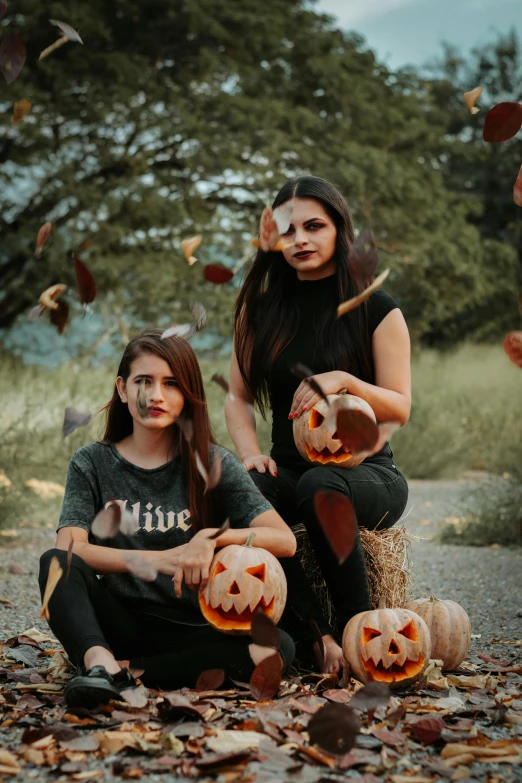 two girls in costumes holding jack o lantern