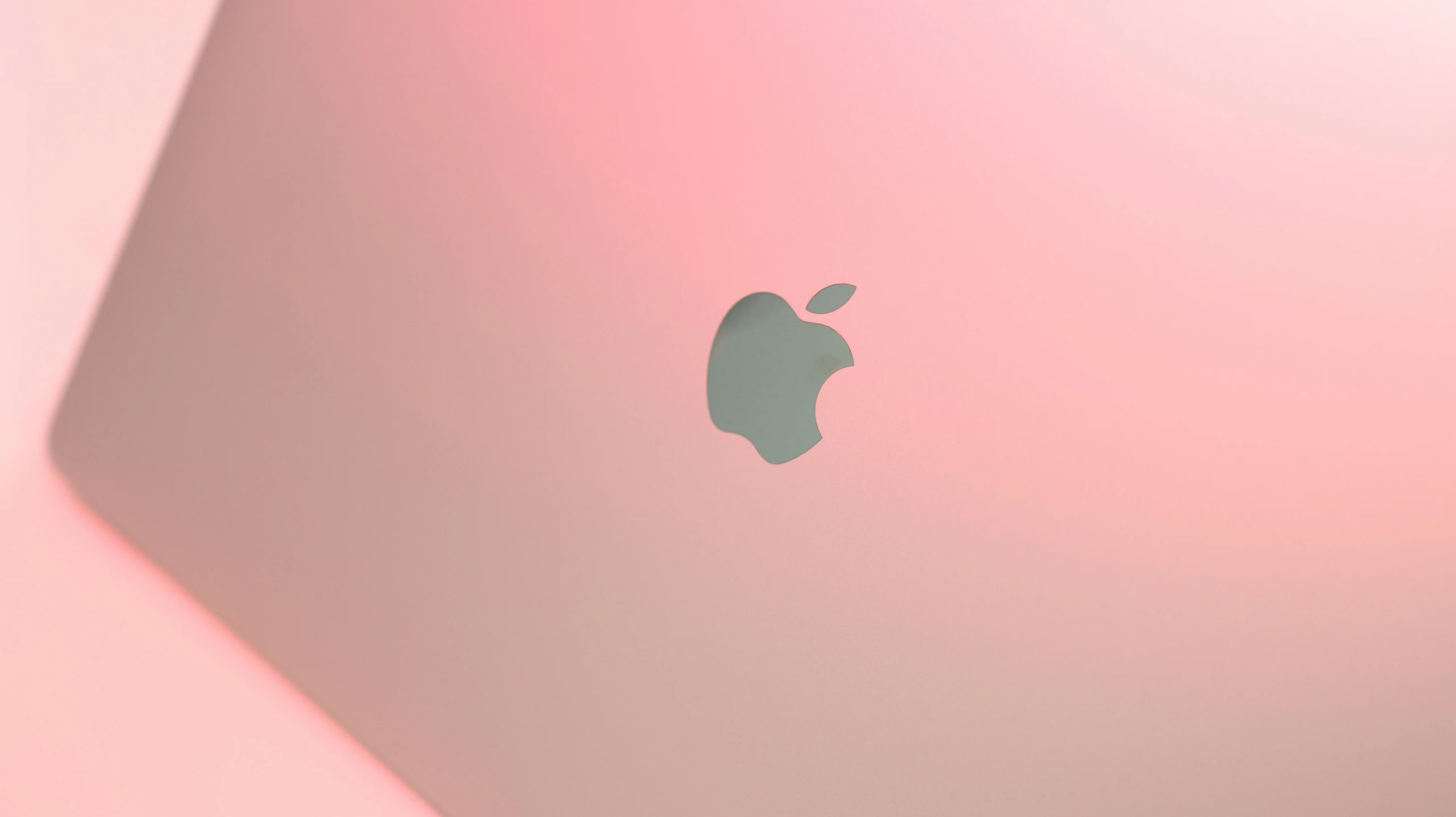 a pink laptop with apple stickers on it