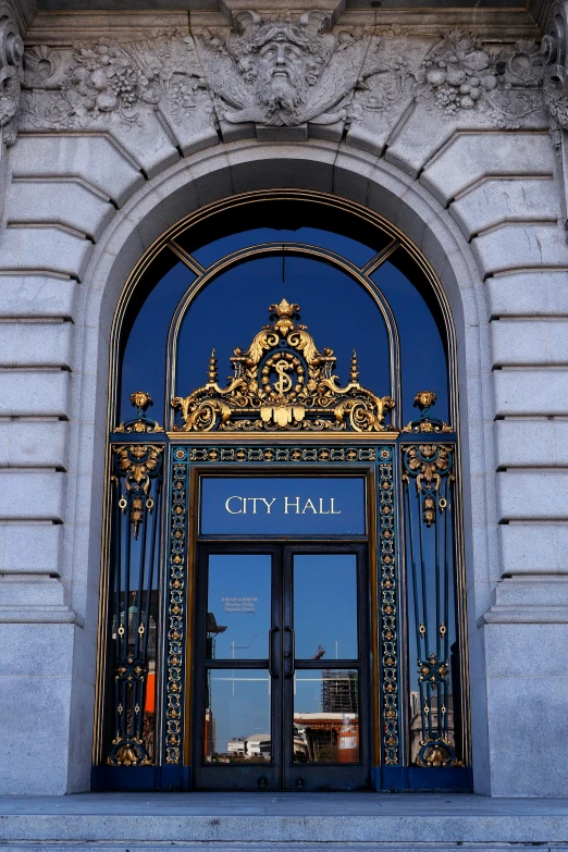 the front door to an office building with a gold archway and ornate architecture