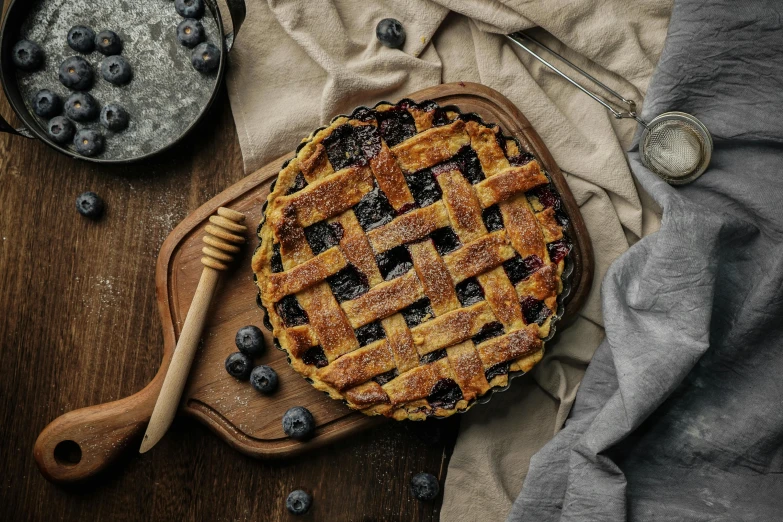 blueberries and pie next to a wooden bowl