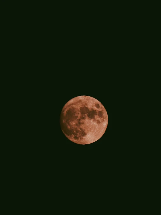 an airplane flying in front of a big, pink full moon