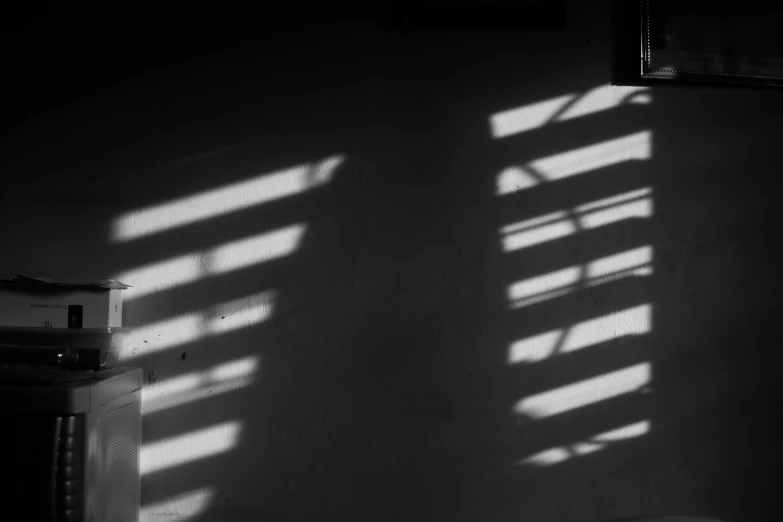 a black and white po of a wall with blinds on it