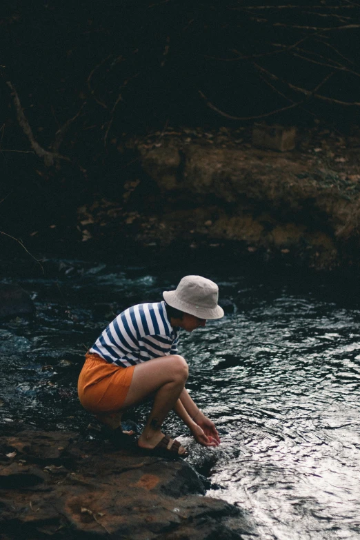 a person that is kneeling down in a body of water