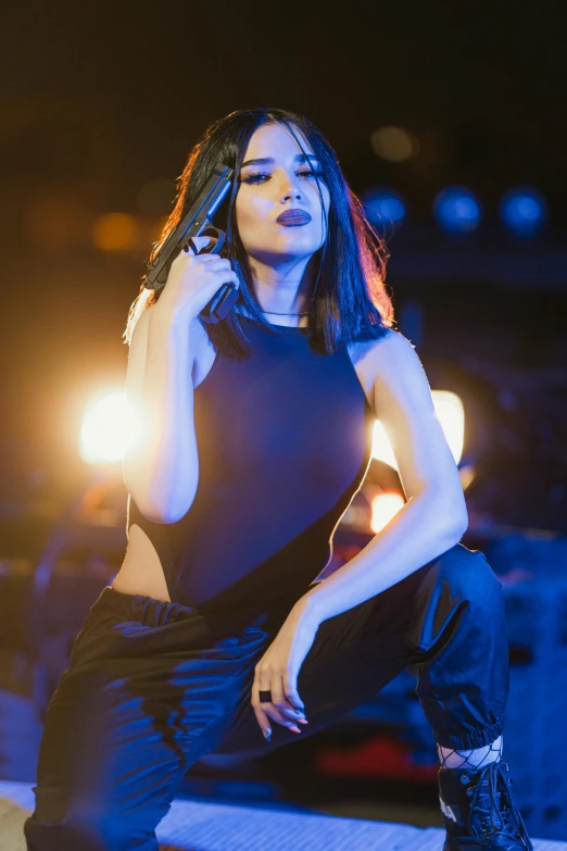 a woman in black clothing posing on stage