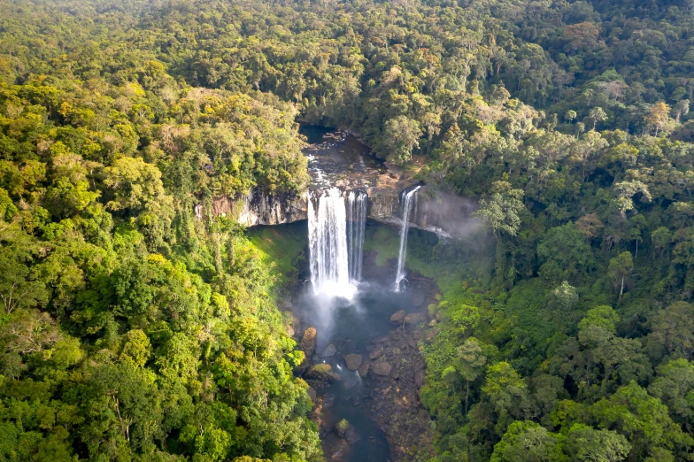 aerial view of water pouring from upper and lower falls in rainforest