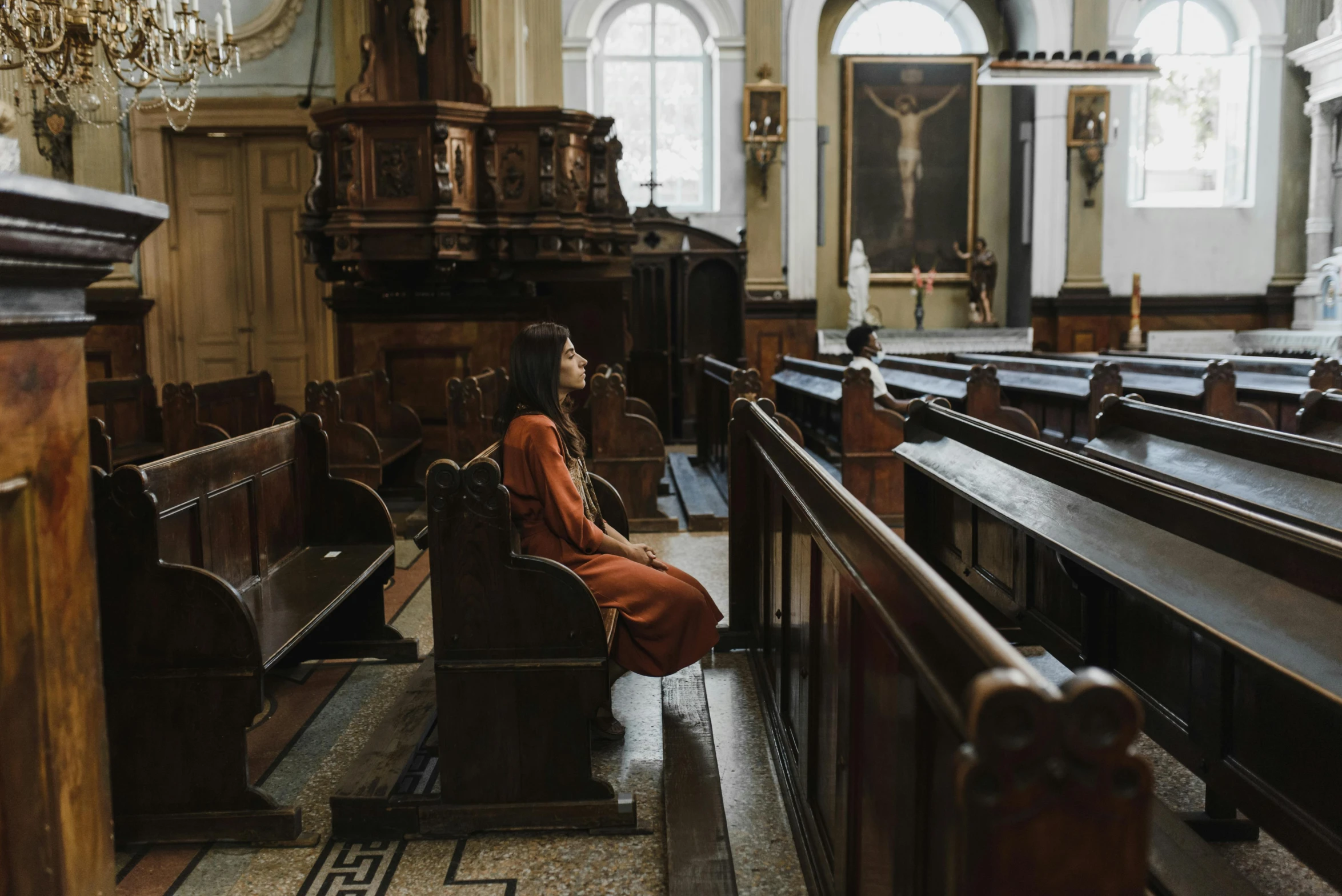 a woman sitting down next to the pews