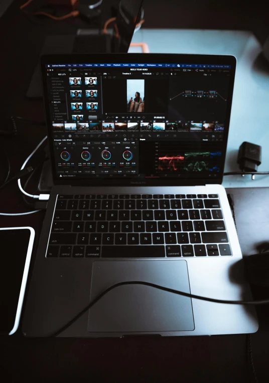 the laptop is next to two others on the desk