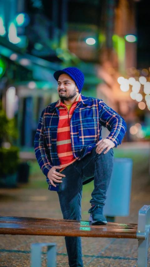 a man leaning on a bench at night in the city