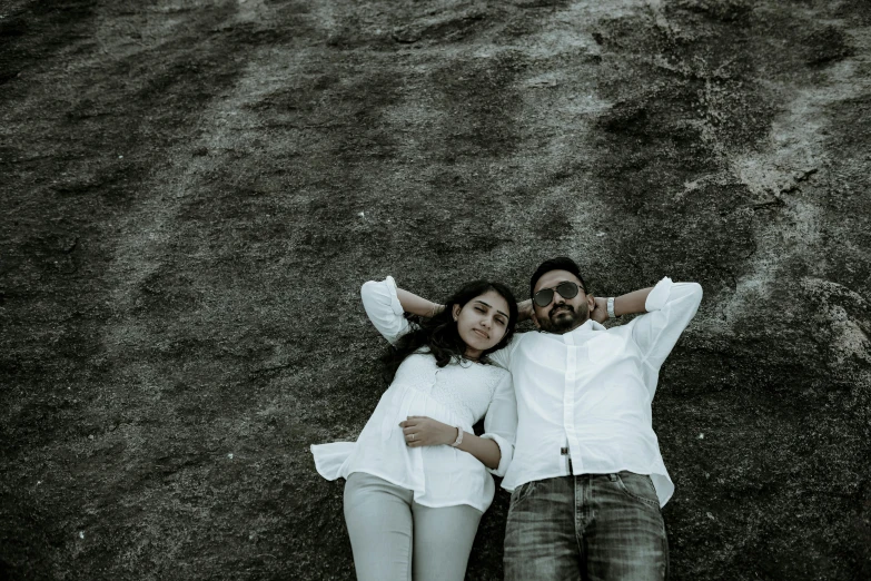 an overhead view of a young couple lying on a hill