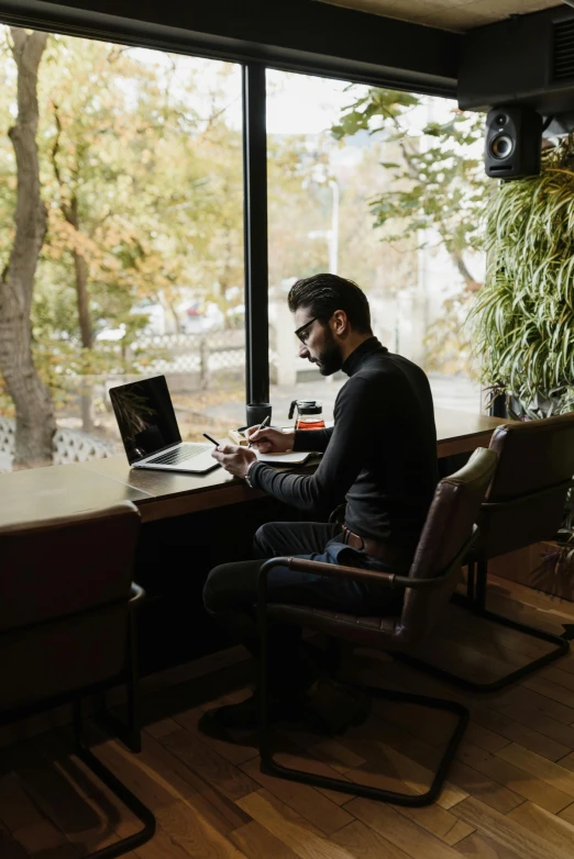 a man sitting at a desk with a laptop