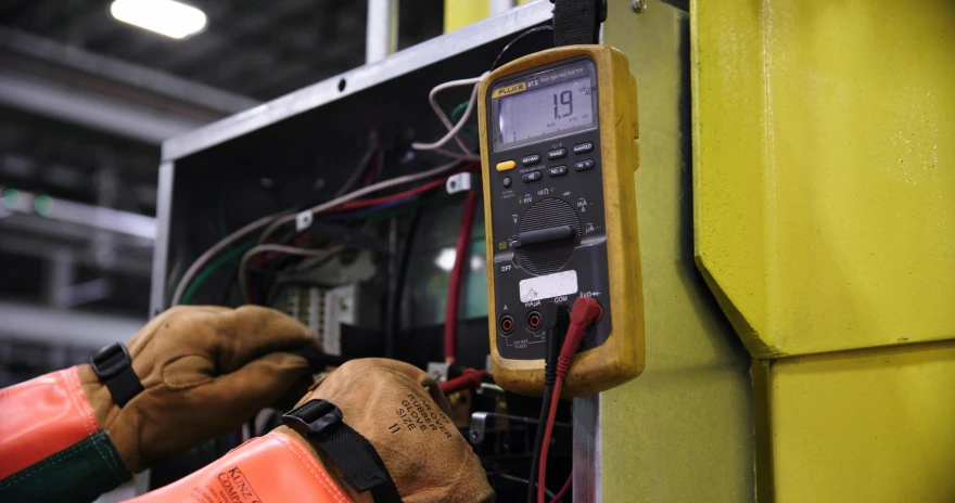 two work gloves and an electric meter in the process of servicing