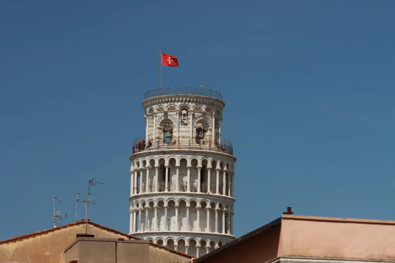 a tall tower with a red flag flying from it's roof