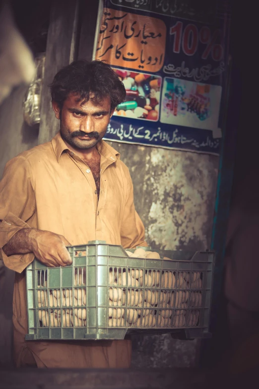 a man carries a metal basket filled with items