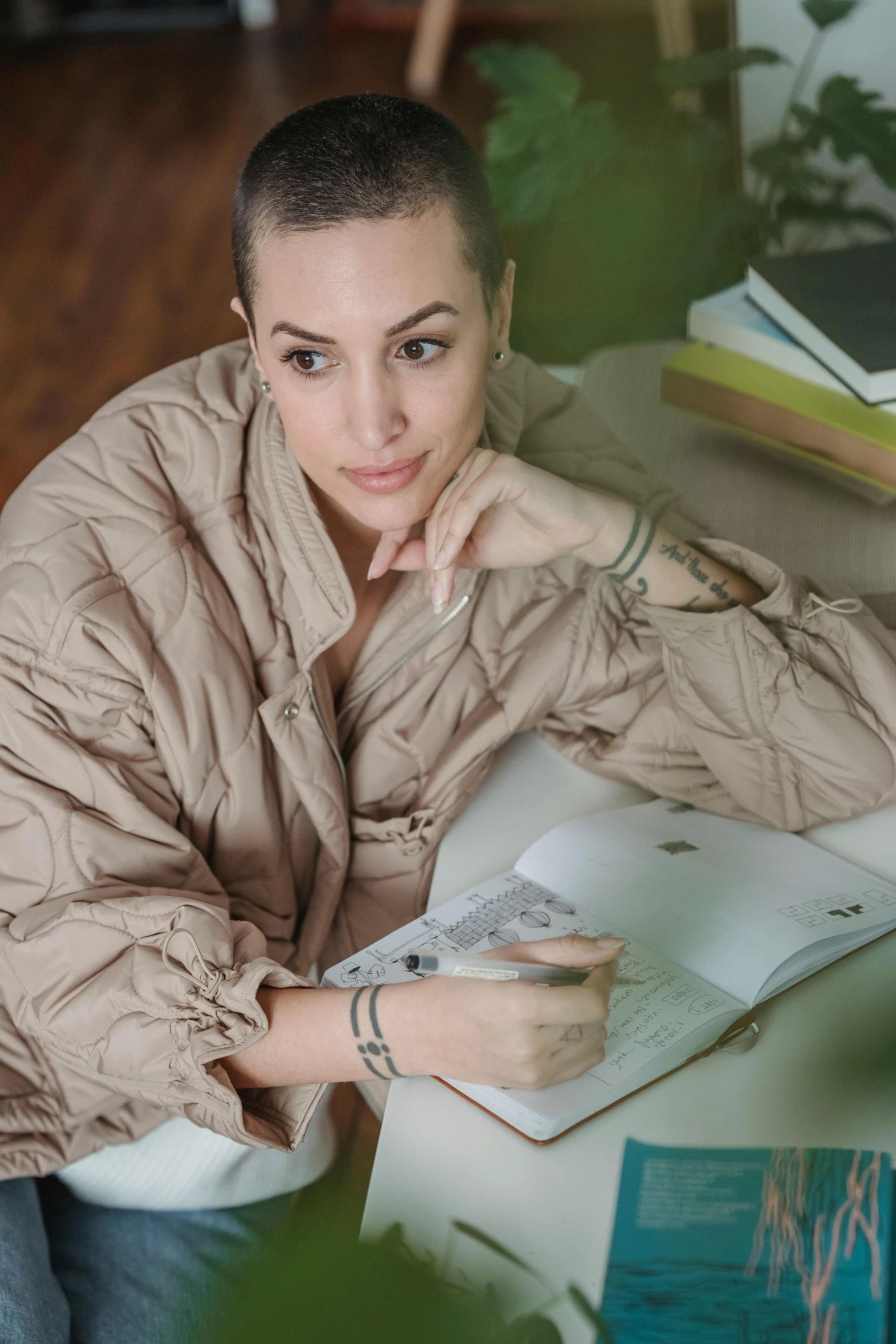 a girl sitting at a table holding a book