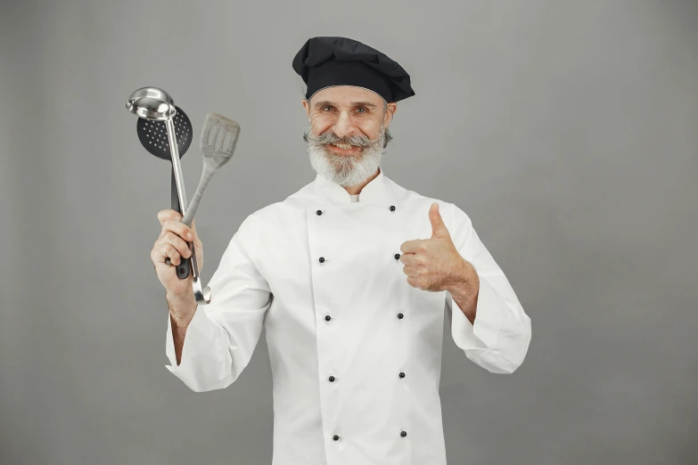 an old man is holding spoons and giving the thumbs up