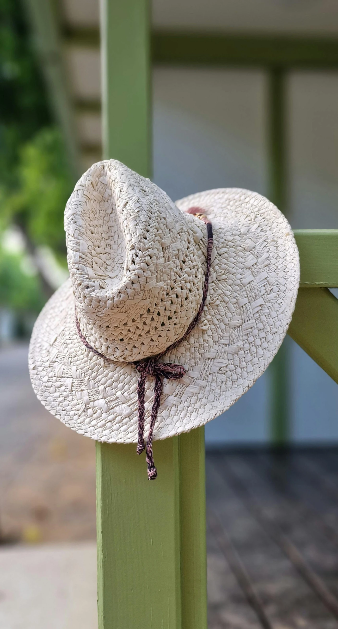 the hat is sitting on top of the wooden rail