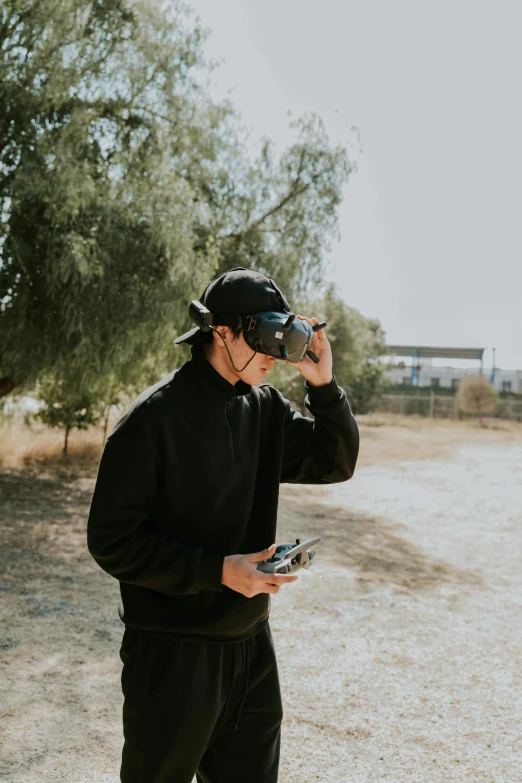 a man in black clothes and a blindfold holding a camera