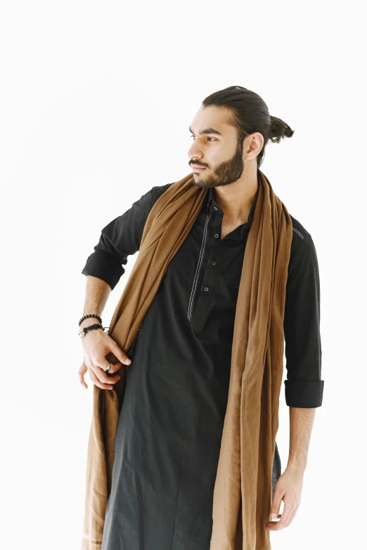 man with beard, wearing brown shawl standing in front of white background