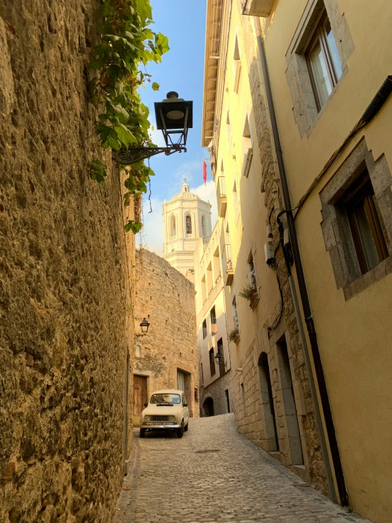 a view of some buildings from the side with an old car in the street