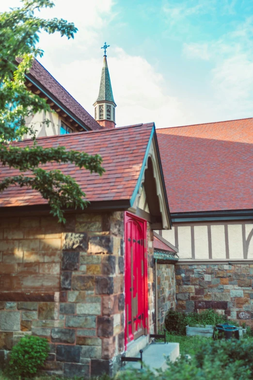 an old brick house with a red door and chimney