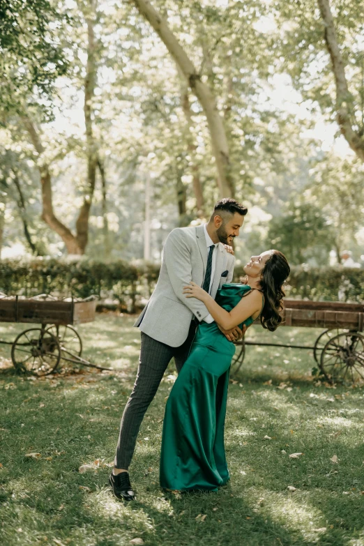 a man and woman dance in a park