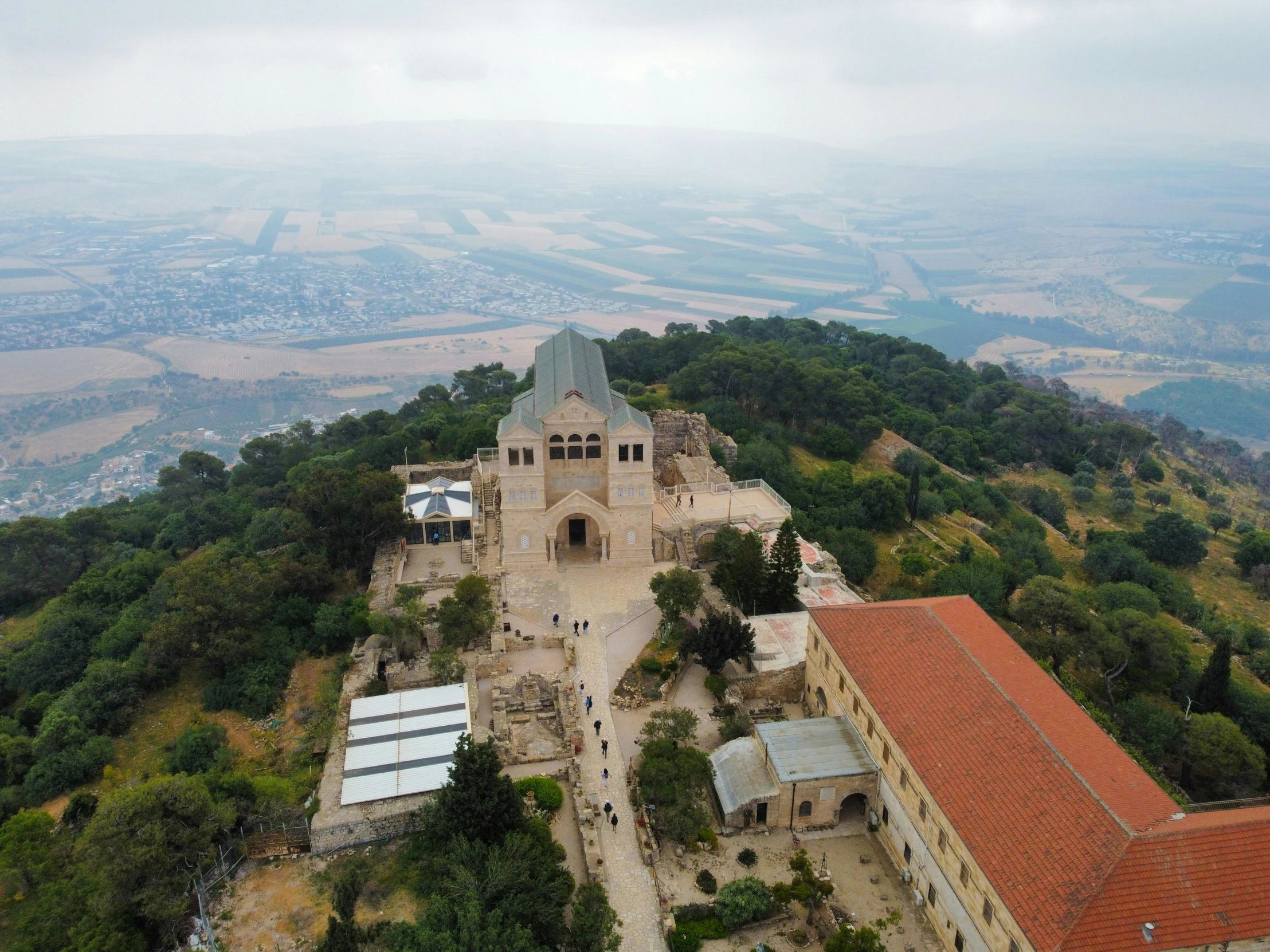 the building with orange roof sits on top of the mountains