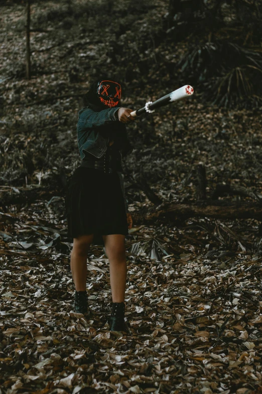 a man with a baseball bat in a wooded area