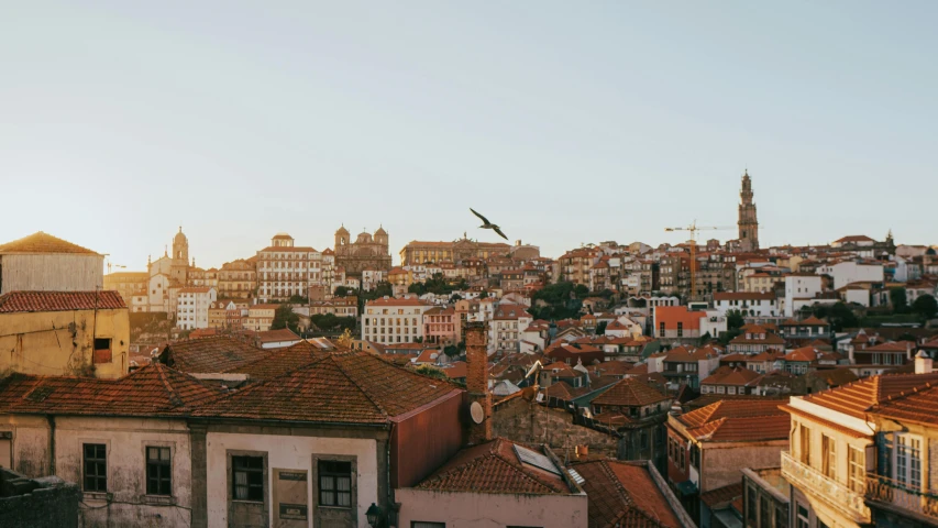 the sun is setting in a city that is full of old buildings