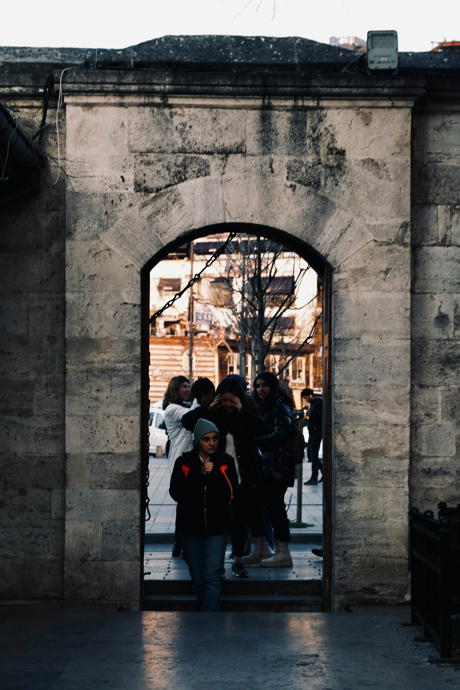 people stand in a doorway in an old wall