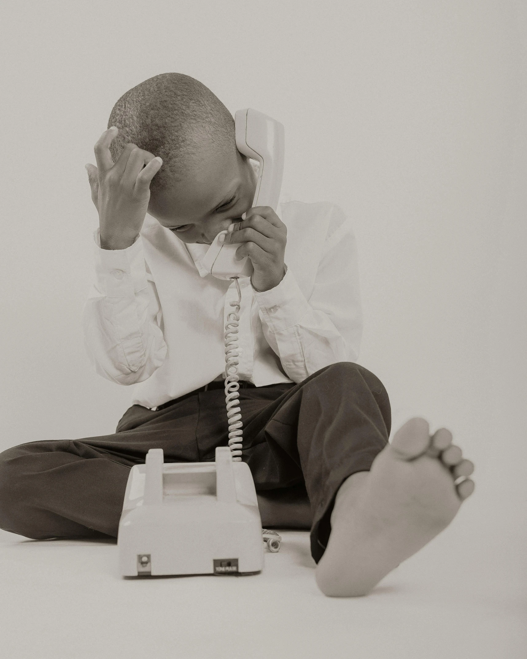 a person sitting on the floor talking on a phone