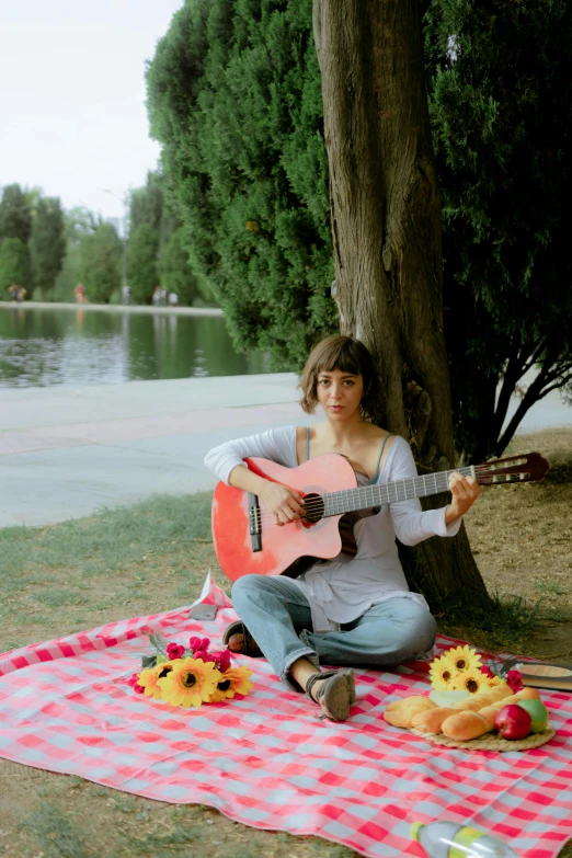 a person that is sitting down playing the guitar