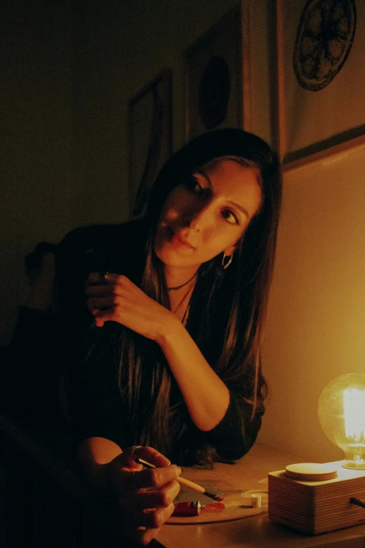 a woman is sitting next to a table with food and a candle