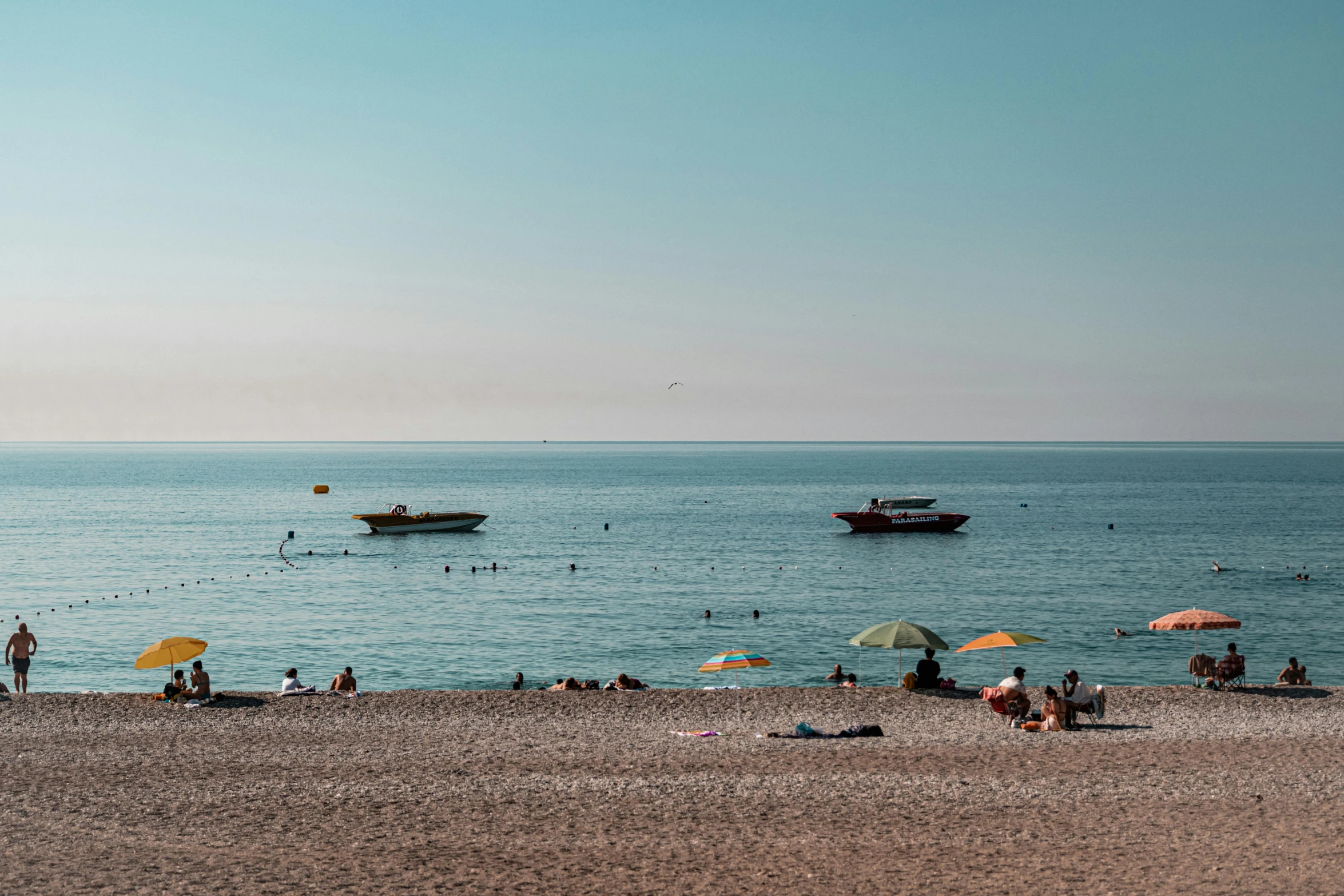 the large group of people are swimming at the beach