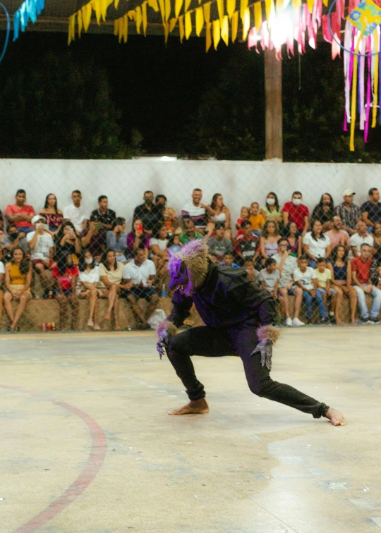 a person skating on one knee while people watch