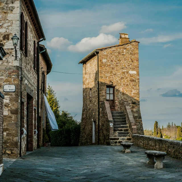 the view from the street of stone buildings with a staircase leading to the roof