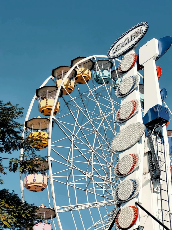 a ferris wheel on a blue day with people around it