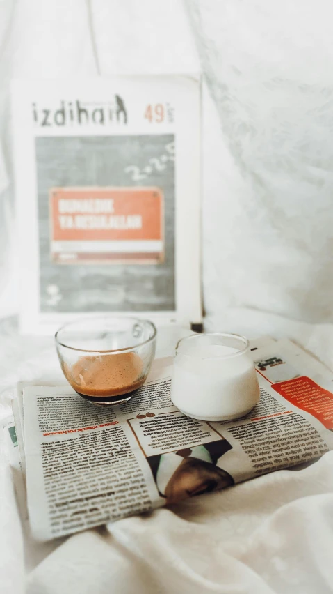 a cup of coffee sitting on top of a news paper