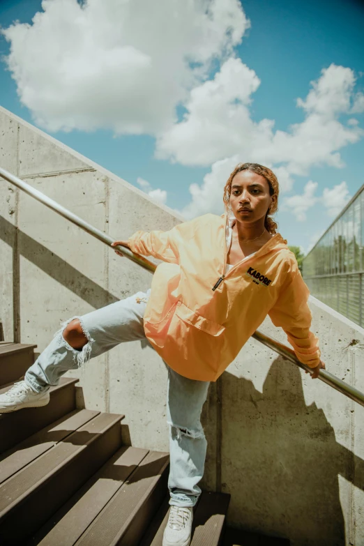 a woman in an orange shirt stands on the stairs